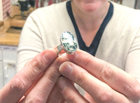 A student holds up a new ring made in class at Metalwerx