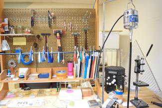 A jeweler's bench well organized with tools and notebooks