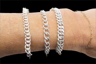 New.three silver curb chains on wrist