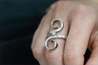 Vanaria.scroll silver ring on hand