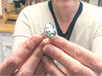 A student holds up a new ring made in class at Metalwerx